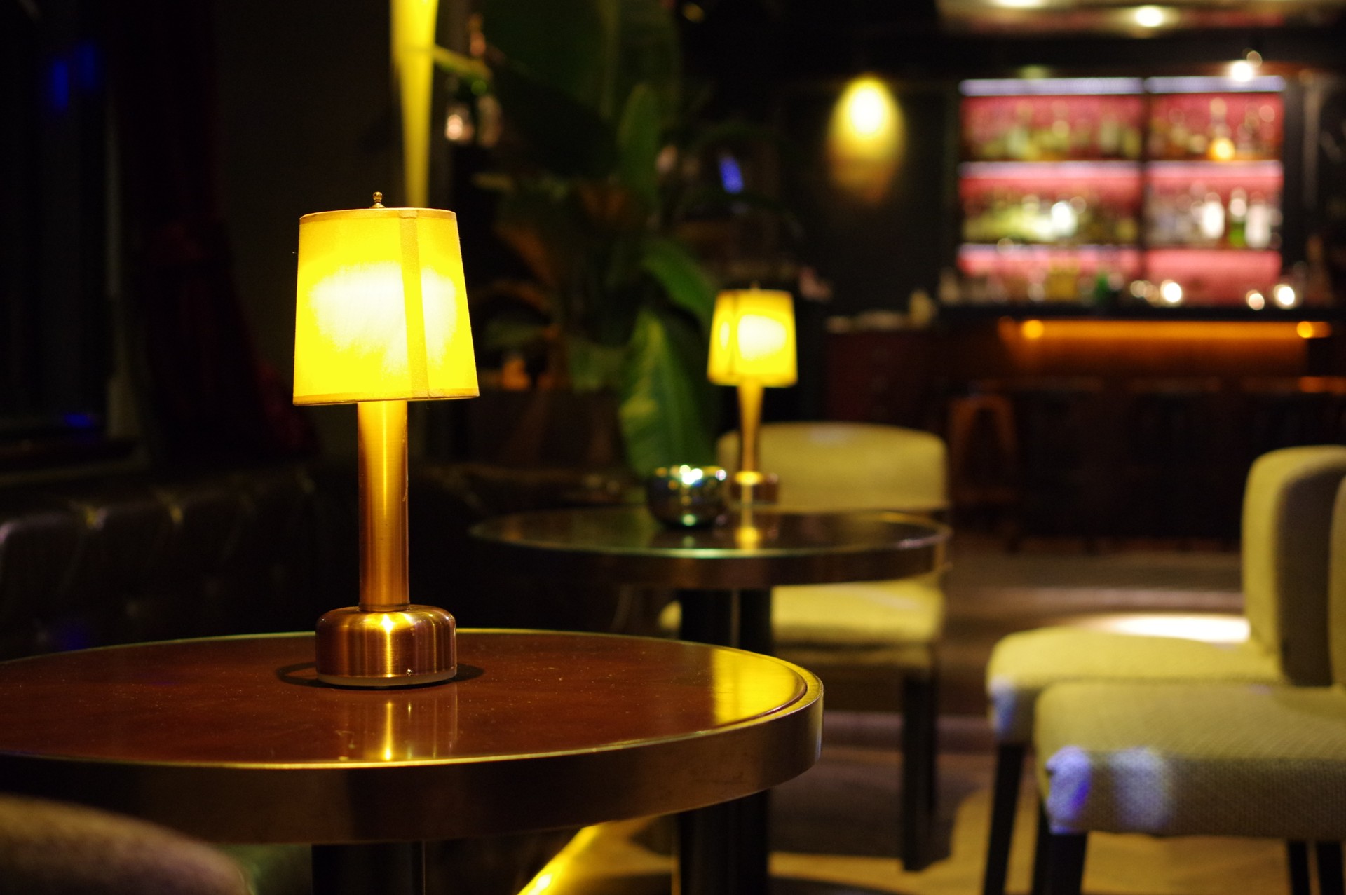 Table lamp on round bartable with gray chair and lounge counter at background